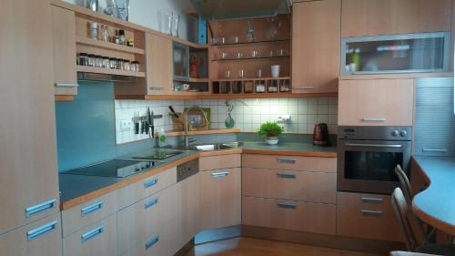 una cocina con armarios de madera y electrodomésticos de acero inoxidable en Brunetti Design Zlín, en Zlín