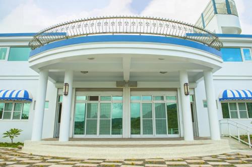 a large white building with a round entry way at Hot Spring Hill B&B in Checheng