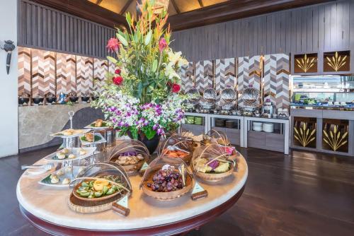 a table with many baskets of food and flowers at Samui Jasmine Resort - SHA Plus in Lamai