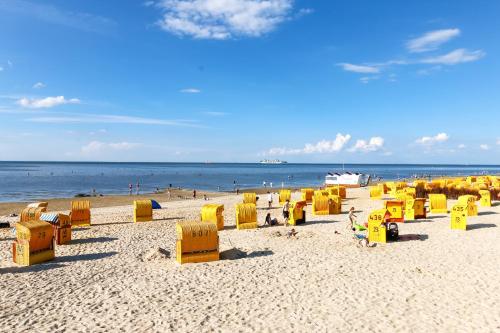 a group of yellow chairs on a beach at Strandhotel Duhnen in Cuxhaven