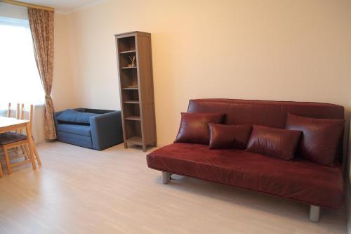カリーニングラードにあるCozy appartment in the city centerのリビングルーム(赤いソファ、青い椅子付)