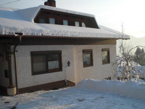 a house with snow on the roof of it at Ferienwohnungen Eggarter in Fresach