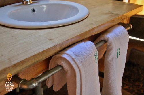 two towels are hanging from a bathroom sink at Kara-Tunga Safari Camp in Moroto