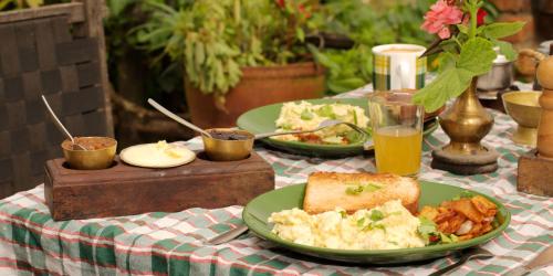 a table with two plates of food and drinks at The Old Inn in Bandipur