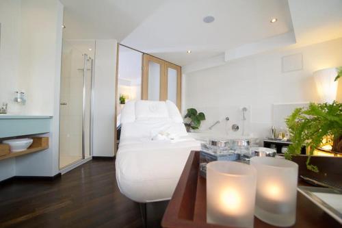 a room with a white bed and a table with lights at Strandhotel Duhnen in Cuxhaven