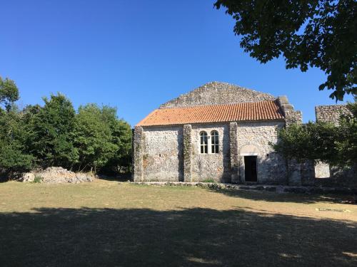 an old stone building with a red roof at Apartments Michael & Petra , Omisalj, Insel Krk, Kroatien in Omišalj