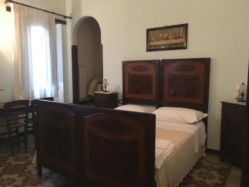 a bedroom with a large wooden bed and a window at Carretiello in Roccadaspide