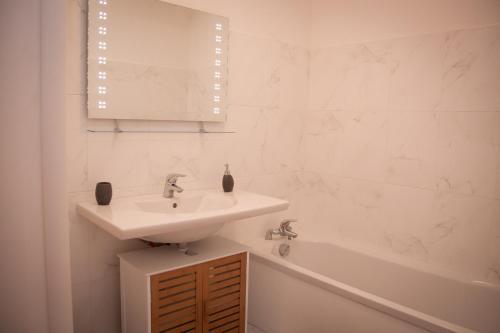 une salle de bain blanche avec un lavabo et une baignoire dans l'établissement Résidence Villa Tyrrenia, à Macinaggio