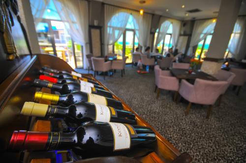 una fila de botellas de vino en una mesa en un restaurante en Batumi World Palace, en Batumi