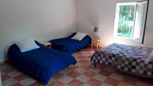 une chambre avec deux lits et une fenêtre dans l'établissement 10 bis, à Lagorce
