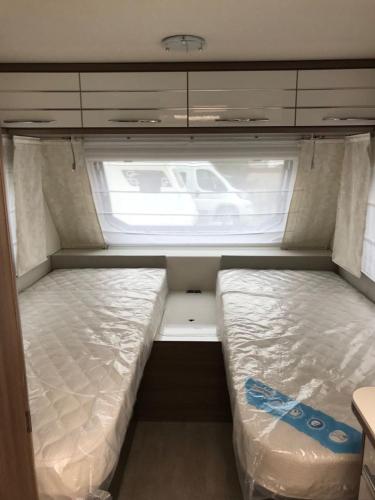 a small room with two beds in an rv at Erlebniscamping Lausitz - Campingplatz Ortrand / Camping Dresden in Ortrand