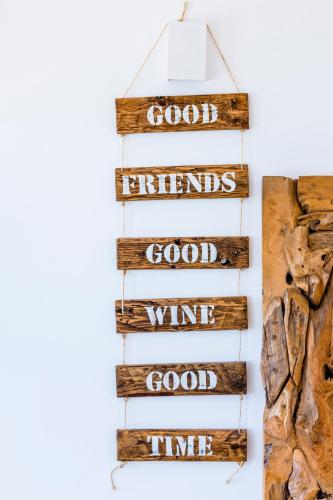 a wooden sign that reads good enemies good wine time at Sandhi House - Yoga & Wellness in Ericeira