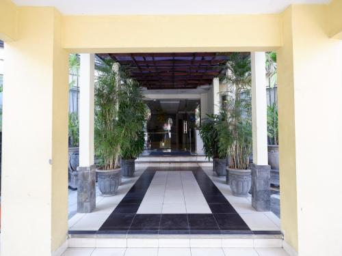 an entrance to a building with a hallway with potted plants at RedDoorz Plus @ Singosari Raya in Semarang