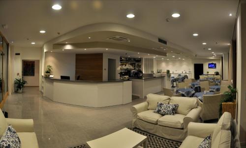 a lobby with couches and a bar in a building at Tullio Hotel in Gravedona