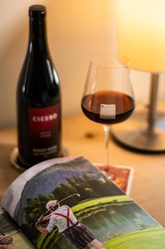 a glass of wine next to a bottle of wine at Hotel Donatz in Samedan