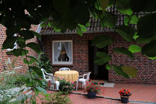a brick house with a table and chairs in the window at Ferienwohnungen / Ferienhaus Wahlers in Bispingen