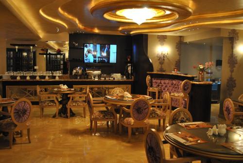 a restaurant with tables and chairs and a flat screen tv at Q Hotel in Beirut