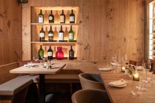 a restaurant with two tables and bottles of wine at Hotel Donatz in Samedan