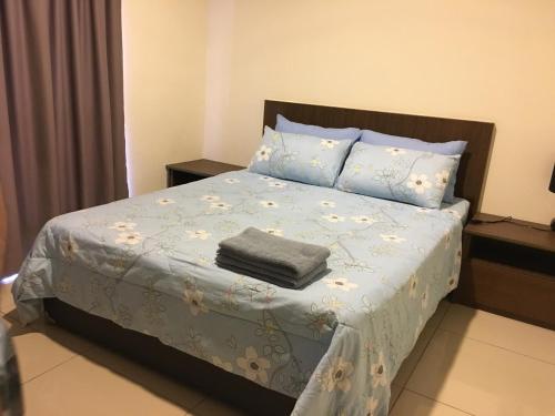 a bedroom with a bed with a blue blanket and pillows at Homestay FaZa @ SG Resort Residence in Kampung Sungai Karang