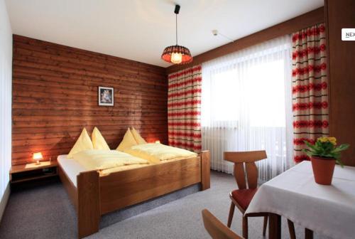 a bedroom with a bed with a brick wall at Pension Mannharthof in Westendorf