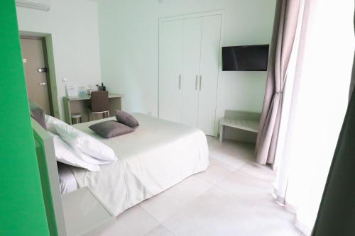 a white bedroom with a bed and a television at Toledo 16 Luxury Suites in Naples