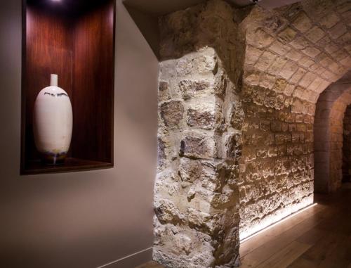 a white vase sitting on a shelf next to a stone wall at Hotel Armoni Paris in Paris