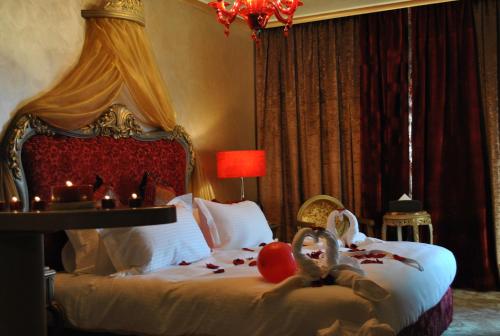 a bedroom with a bed with candles and stuffed animals on it at Q Hotel in Beirut