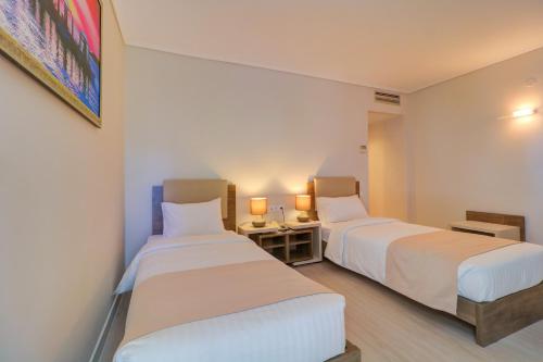 dwa łóżka w pokoju hotelowym z dwoma lampami w obiekcie Palace Hotel Glyfada w Atenach