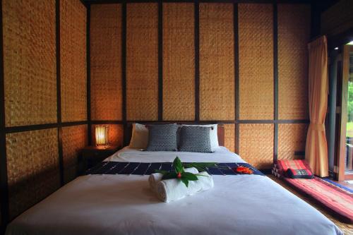 a bedroom with a bed with towels on it at Azalea Village in Chiang Dao