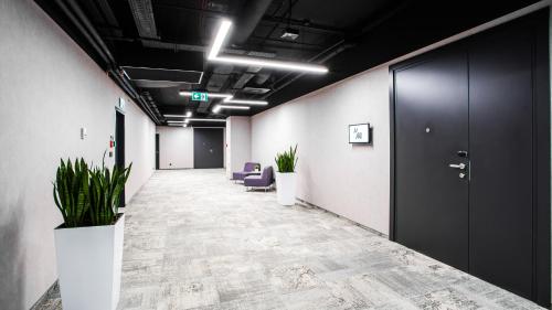 an office hallway with purple chairs and plants at ibis Styles Warszawa City in Warsaw
