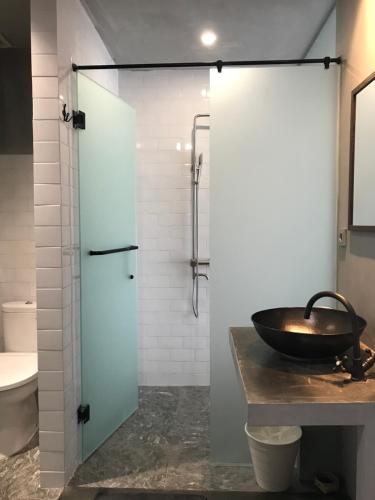 a bathroom with a sink and a glass shower at the AMARTYA in Yogyakarta