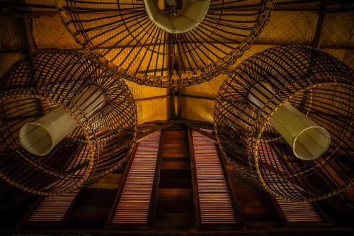 a room with a ceiling with two fans and windows at Azalea Village in Chiang Dao