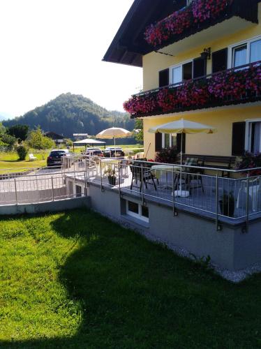 a balcony of a building with tables and umbrellas at Haus Amalia in Strobl