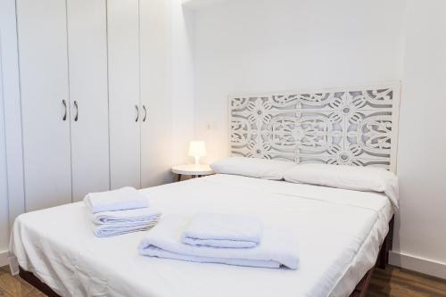 una camera da letto bianca con armadi bianchi e asciugamani su un letto di Amazing Sea Views with AC two min beach ad Alicante