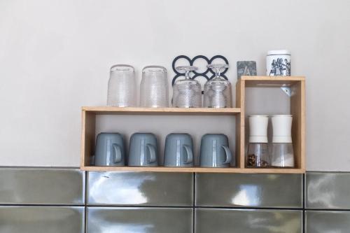 a shelf with plates and other items on it at Momerooms – Appartement am Momering in Oberwesel