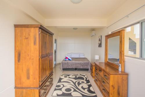 a bedroom with a bed and a dresser and a mirror at Mai'i Villa Apartment - 1 in Titikaweka