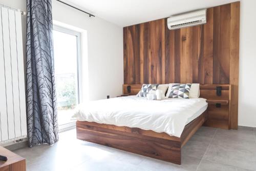 1 dormitorio con 1 cama grande y cabecero de madera en Vila Izabela, en Križevci pri Ljutomeru