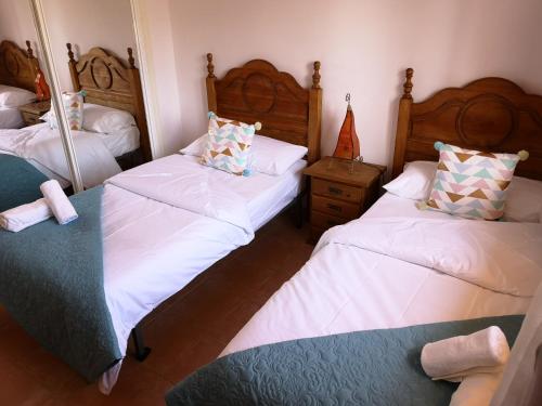 een slaapkamer met 2 bedden en een spiegel bij VV Sweet Tabaiba "by henrypole home" in Los Cancajos