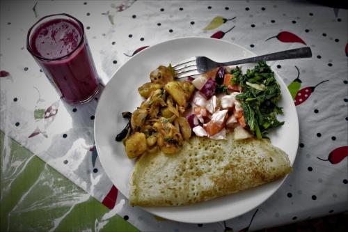 a plate of food with a slice of pizza and a fork at Yog Hostel- Rooftop Yoga & Backpacker Social Stay in Thamel, Kathamndu in Kathmandu