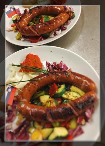 two plates of food with sausage and vegetables on them at Guesthouse Stari Mayr in Kranj