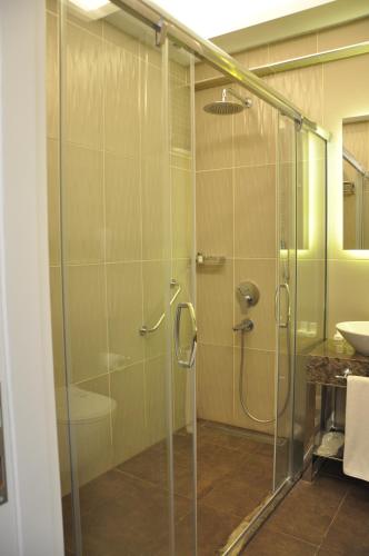 a bathroom with a glass shower with a sink at Centrum Suites İstanbul in Istanbul