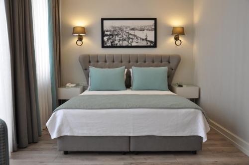 a bedroom with a large bed with blue pillows at Centrum Suites İstanbul in Istanbul
