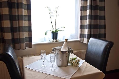 a table with a bottle and glasses on a table at Tricky's Hotel in Redruth