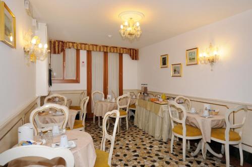 a restaurant with tables and chairs in a room at Hotel Il Mercante di Venezia in Venice