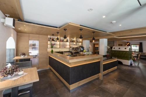 a kitchen with a bar in a restaurant at Zur Brücke in Mittewald - Your home in heart of South Tyrol, with Brixencard and free parking, ideal starting point for unforgettable excursions and outdoor adventures in Fortezza