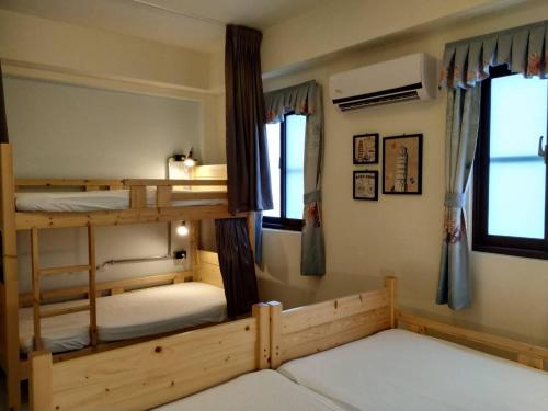 a bedroom with two bunk beds and two windows at Backpack Home 497 in Jinhu