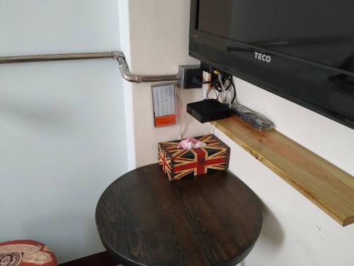 a table with a box on a table under a television at Backpack Home 497 in Jinhu