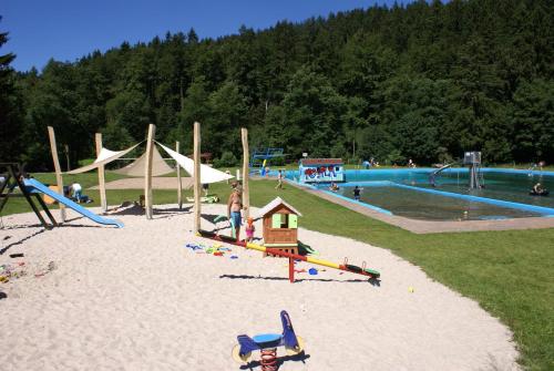 um parque com um parque infantil com escorregas e uma piscina em Ferienhaus Lichtung em Ruhla