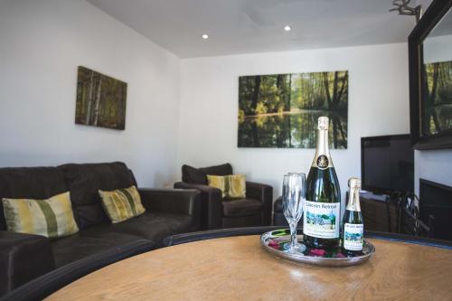 two bottles of wine on a table in a living room at Lincoln Holiday Retreat Cottage with Private Hot Tub in Lincoln