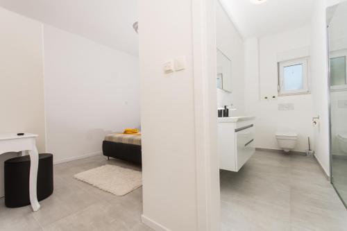 biała łazienka z umywalką i toaletą w obiekcie Apartment JULIA w Trogirze